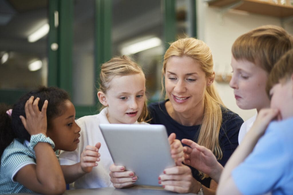 teacher-with-schoolboys-and-girls-looking-at-digit-2023-11-27-05-34-47-utc
